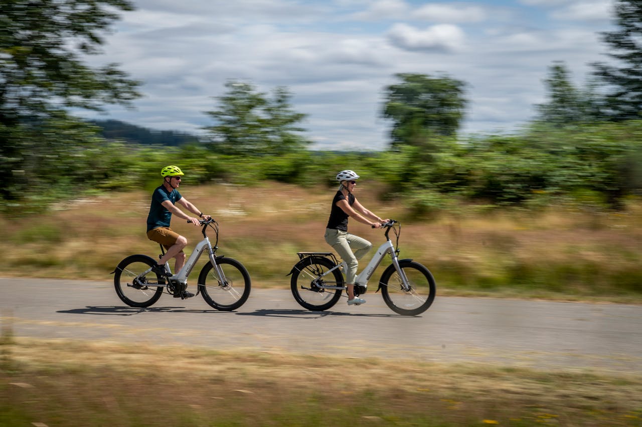 A couple enjoying a leisurely ride on electric bikes in Seattle's scenic outdoors.